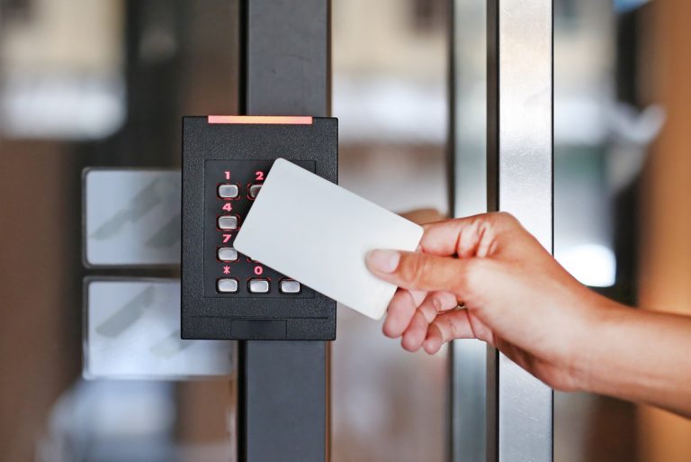 Multifamily Access Control Systems Apartment shopping, Apartment Mystery Shops, Apartment renters Journey A person holds a white access card near an electronic keypad lock on a glass door, illustrating the advanced access control systems often used in multifamily residences. Multifamily Journey Lens CX for the Apartment Industry